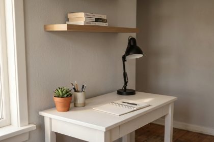 Coin bureau minimaliste et économique avec bureau blanc, accessoires de bureau simples et plante verte dans un appartement